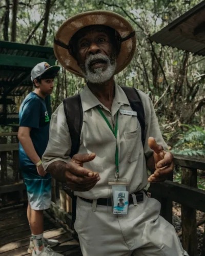 Local guide speaking to travellers in a forest